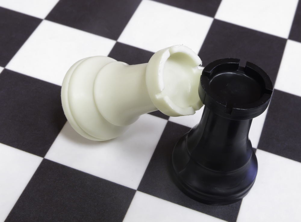 White rook topples against black rook on chessboard